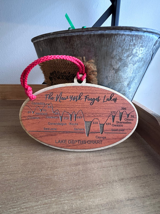 Close-up of engraved lake depth measurements on wood Finger Lakes ornament