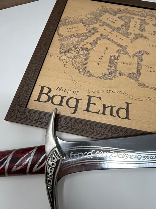 Sword with ornate hilt on a map of 'Bag End' from 'The Lord of the Rings'.