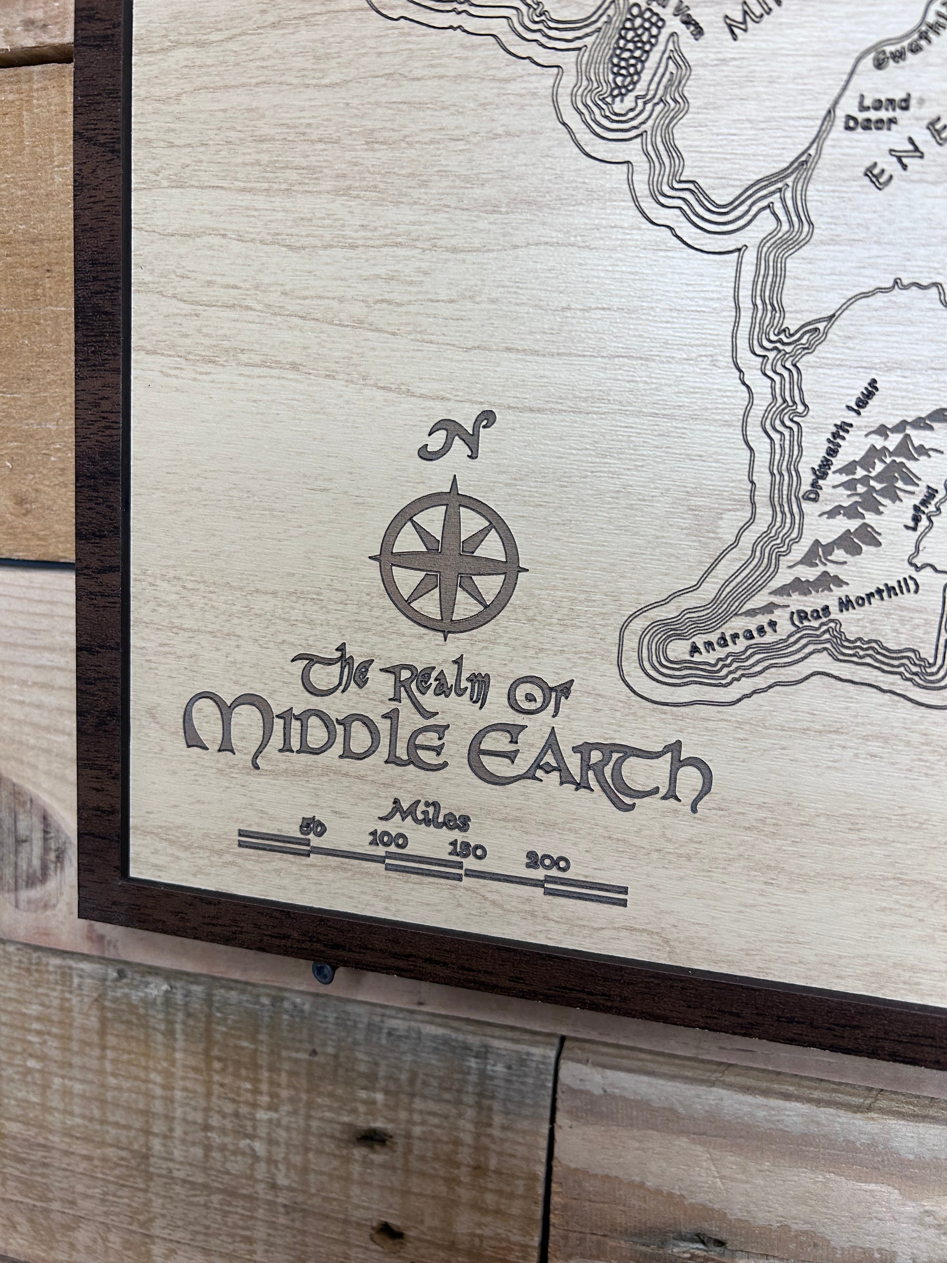 Wooden plaque with engraved map of Middle-earth and 'The Lord of the Rings' logo.