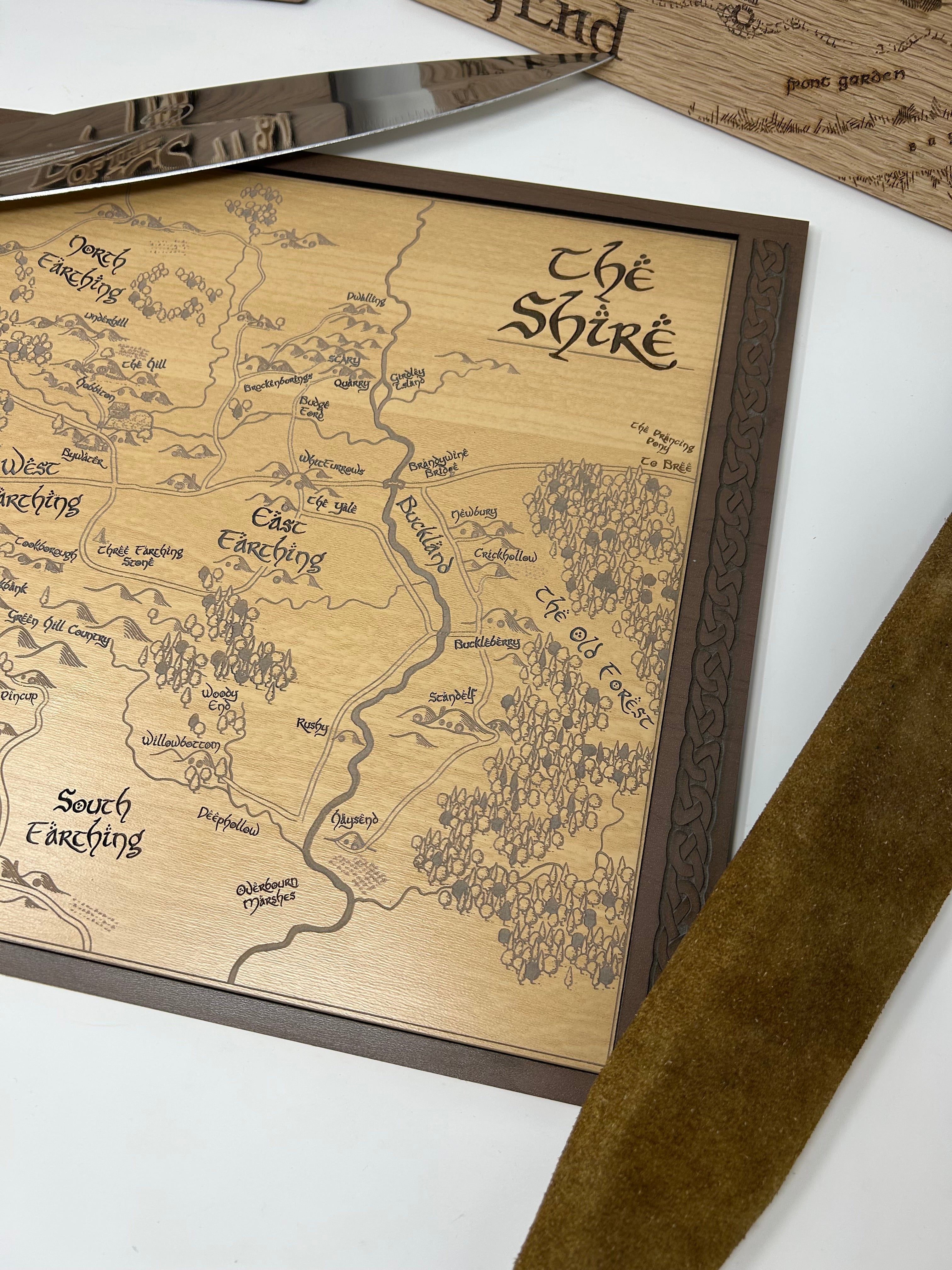Wooden map of 'The Shire' with a brown frame on a white surface.