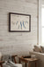 A framed Finger Lakes New York map wall art piece with blue lake outlines and a dark wood frame, mounted on a light gray wall.