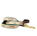 American Traditions ribbon dog collar with leather handle and brass snap and fish and lures decorating the ribbon