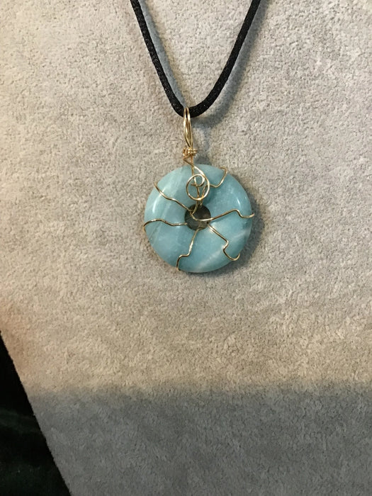 Wire wrapped gemstone donut on 18" black satin adjustable cord.