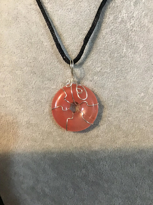 Wire wrapped gemstone donut on 18" black satin adjustable cord.