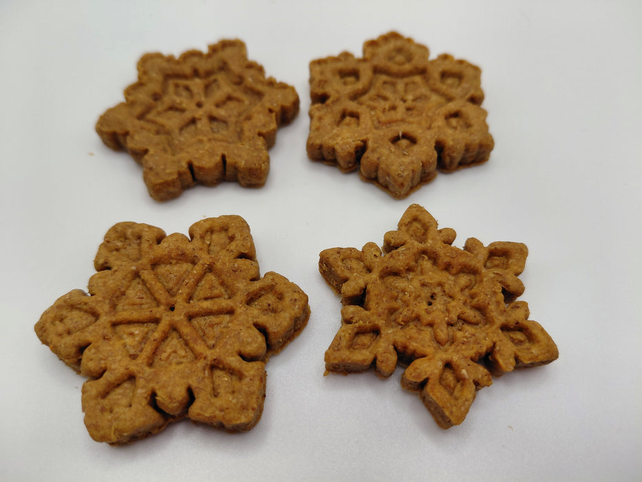 Four Peanut Butter Snowflakes, handmade organic dog treats from The Chose Spot K9 Kitchen on a white background