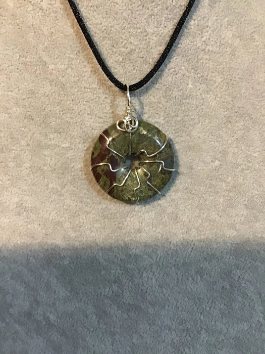 Wire wrapped gemstone donut on 18" black satin adjustable cord.