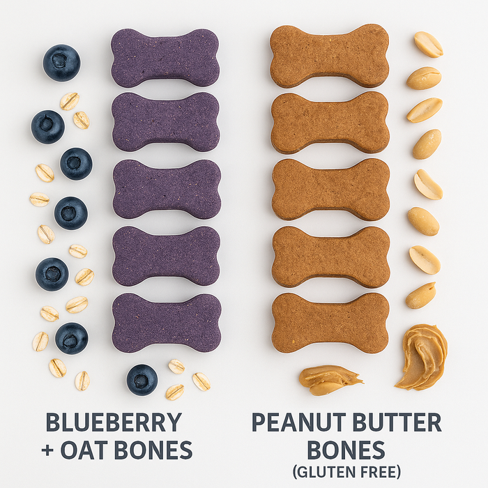 Gluten-Free Peanut Butter Bones and Blueberry + Oat Bones layed out on a white surface. Handmade organic dog treats from 'The Chosen Spot K9 Kitchen' with peanuts, organic peanut butter, organic blueberries and wholegrain oats nearby.