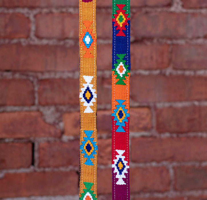 2 different God's Eye colorways in front of a brick background