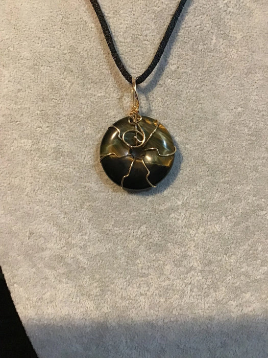 Wire wrapped gemstone donut on 18" black satin adjustable cord.