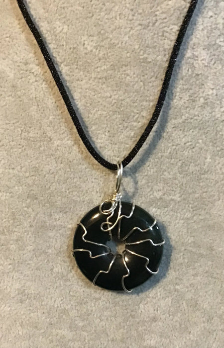 Wire wrapped gemstone donut on 18" black satin adjustable cord.