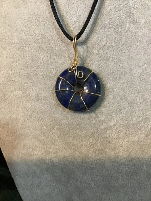 Wire wrapped gemstone donut on 18" black satin adjustable cord.
