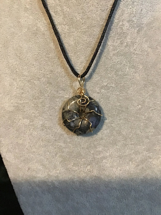 Wire wrapped gemstone donut on 18" black satin adjustable cord.