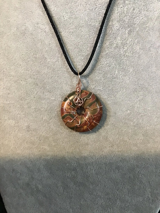 Wire wrapped gemstone donut on 18" black satin adjustable cord.