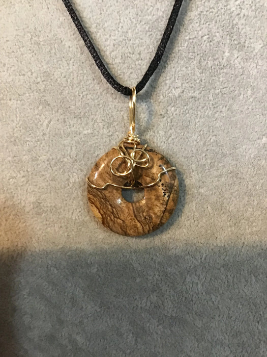 Wire wrapped gemstone donut on 18" black satin adjustable cord.