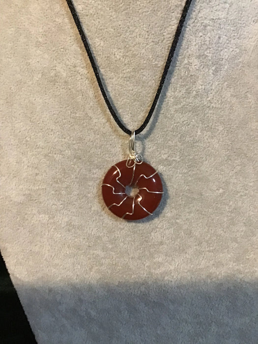 Wire wrapped gemstone donut on 18" black satin adjustable cord.