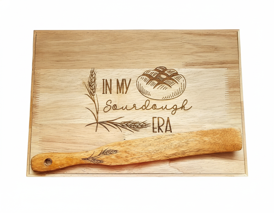 Wooden cutting board with engraved text and a spurtle.