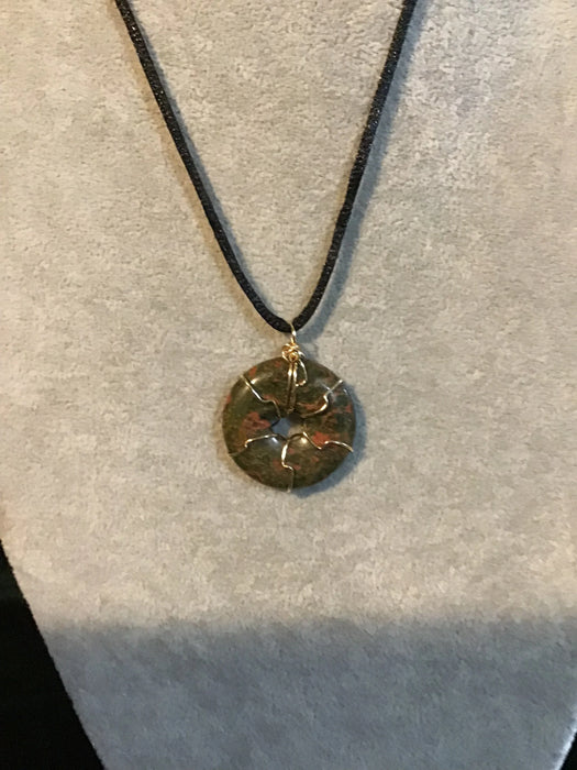 Wire wrapped gemstone donut on 18" black satin adjustable cord.