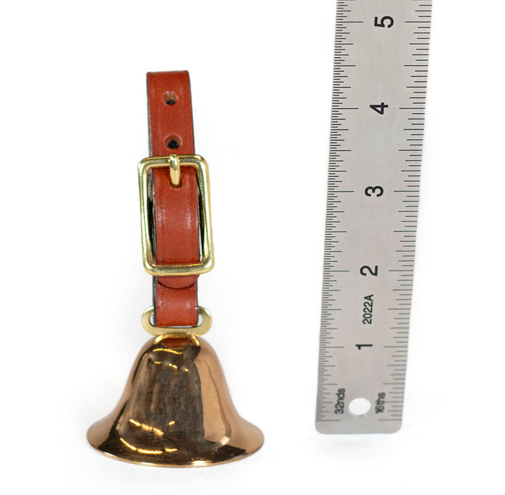 brass sportsmans bird dog bell with tan bridle leather strap. next to ruler showing 4-1/2" tall.