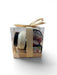 Two small cylindrical products in a clear gift box with a gold ribbon on a white background.
