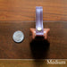 cowbell with antique brass finish and burgundy bridle leather strap shown next to a quarter