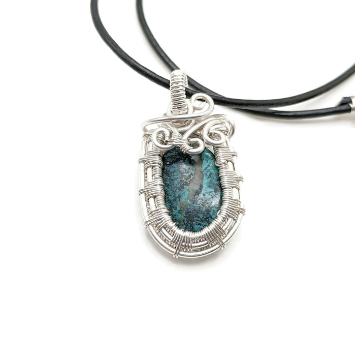 Small turquoise set in a beautiful silver framed pendant, stone is open in the back and is able to touch skin on both sides. Hangs on a black handmade leather cord necklace.