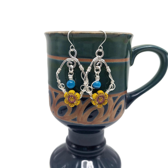 Silver drop earrings with bright blue beads and vibrant yellow sunflowers.