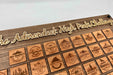 Walnut frame detail — laser-engraved Adirondack High Peaks Challenge header in maple appliqué