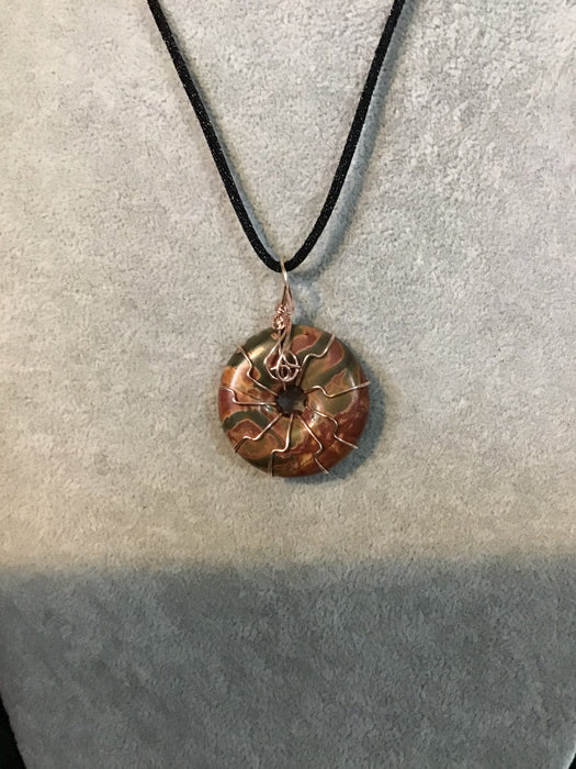 Wire wrapped gemstone donut on18" black satin adjustable cord.