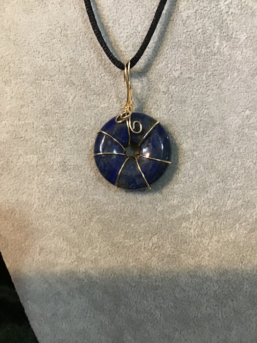 Wire wrapped gemstone donut on18" black satin adjustable cord.