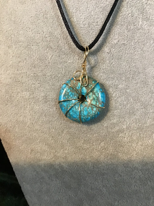 Wire wrapped gemstone donut on18" black satin adjustable cord.