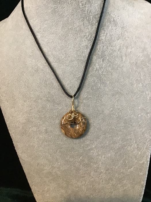 Wire wrapped gemstone donut on18" black satin adjustable cord.