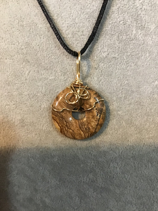 Wire wrapped gemstone donut on18" black satin adjustable cord.