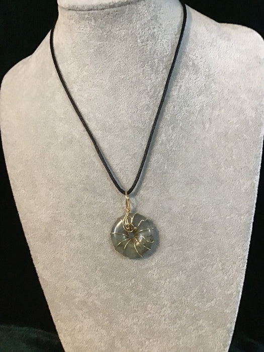 Wire wrapped gemstone donut on18" black satin adjustable cord.