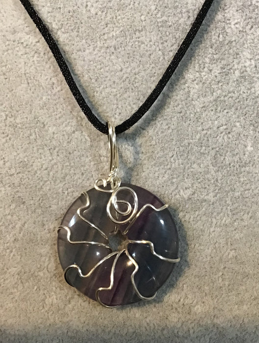 Wire wrapped gemstone donut on18" black satin adjustable cord.