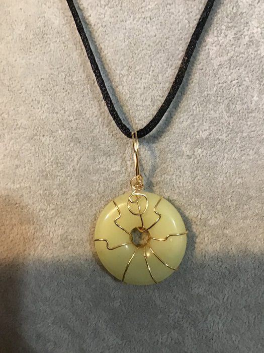 Wire wrapped gemstone donut on18" black satin adjustable cord.