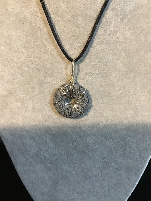 Wire wrapped gemstone donut on18" black satin adjustable cord.