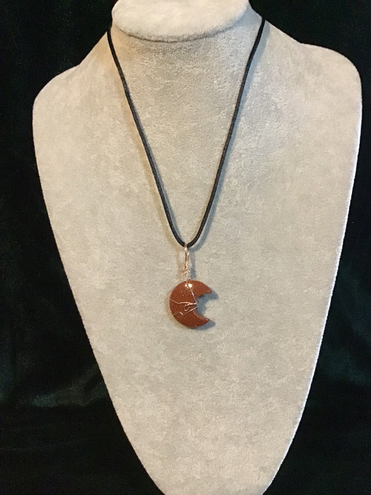 Wire wrapped Gold Red Sandstone crescent moon on a black satin cord.