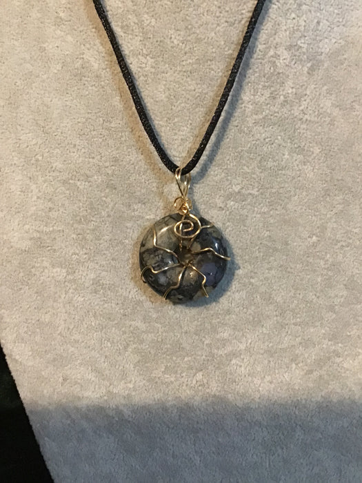 Wire wrapped gemstone donut on18" black satin adjustable cord.