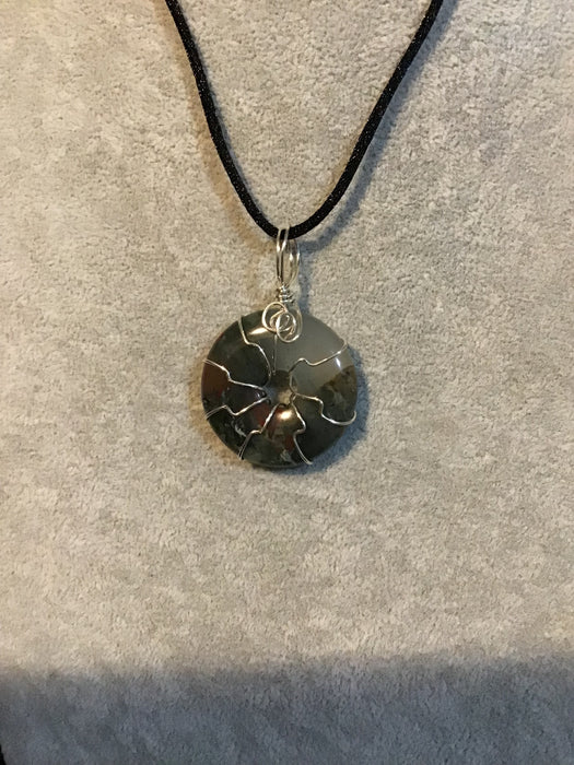 Wire wrapped gemstone donut on18" black satin adjustable cord.