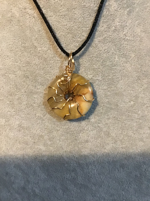 Wire wrapped gemstone donut on18" black satin adjustable cord.