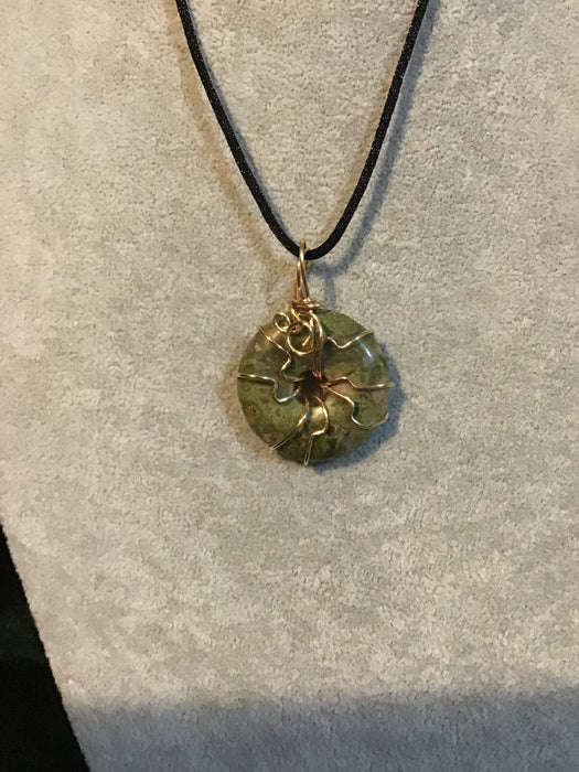 Wire wrapped gemstone donut on18" black satin adjustable cord.