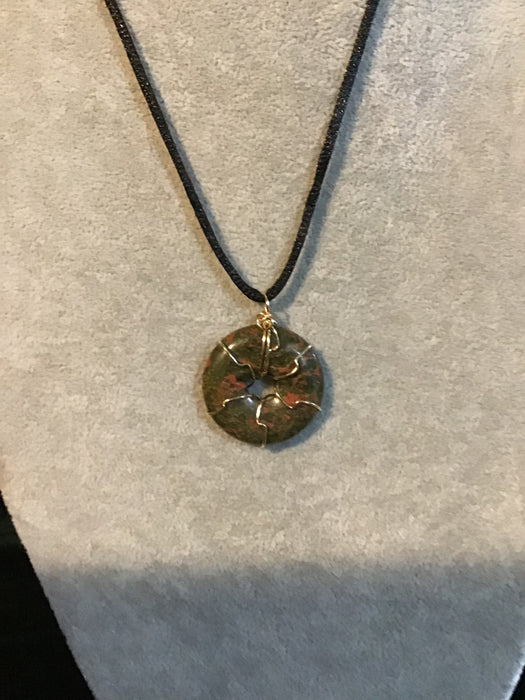 Wire wrapped gemstone donut on18" black satin adjustable cord.