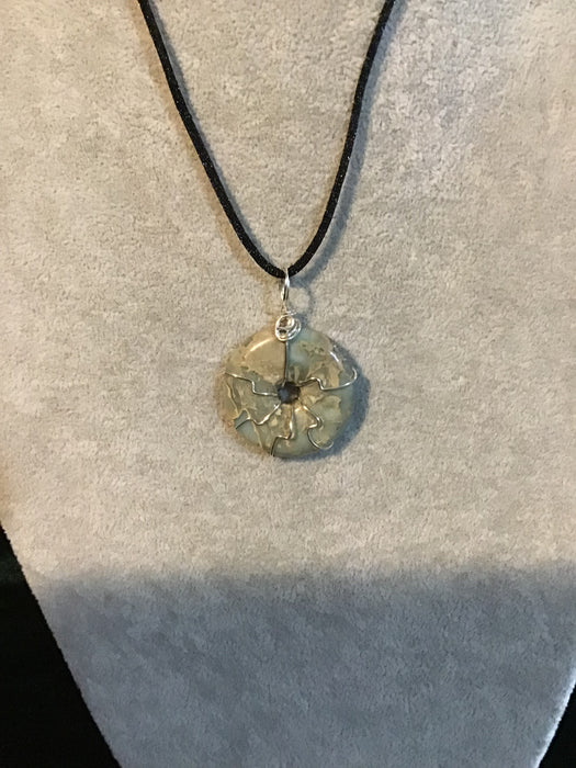 Wire wrapped gemstone donut on18" black satin adjustable cord.