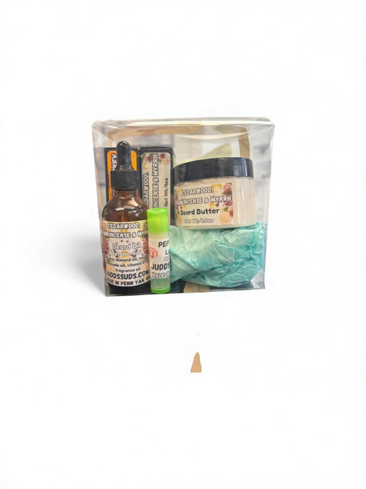 Set of skincare products including a bottle, jar, and other items in a clear bag on a white background.
