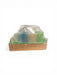 Bar of soap on a wooden soap dish with clear plastic cover on a white background